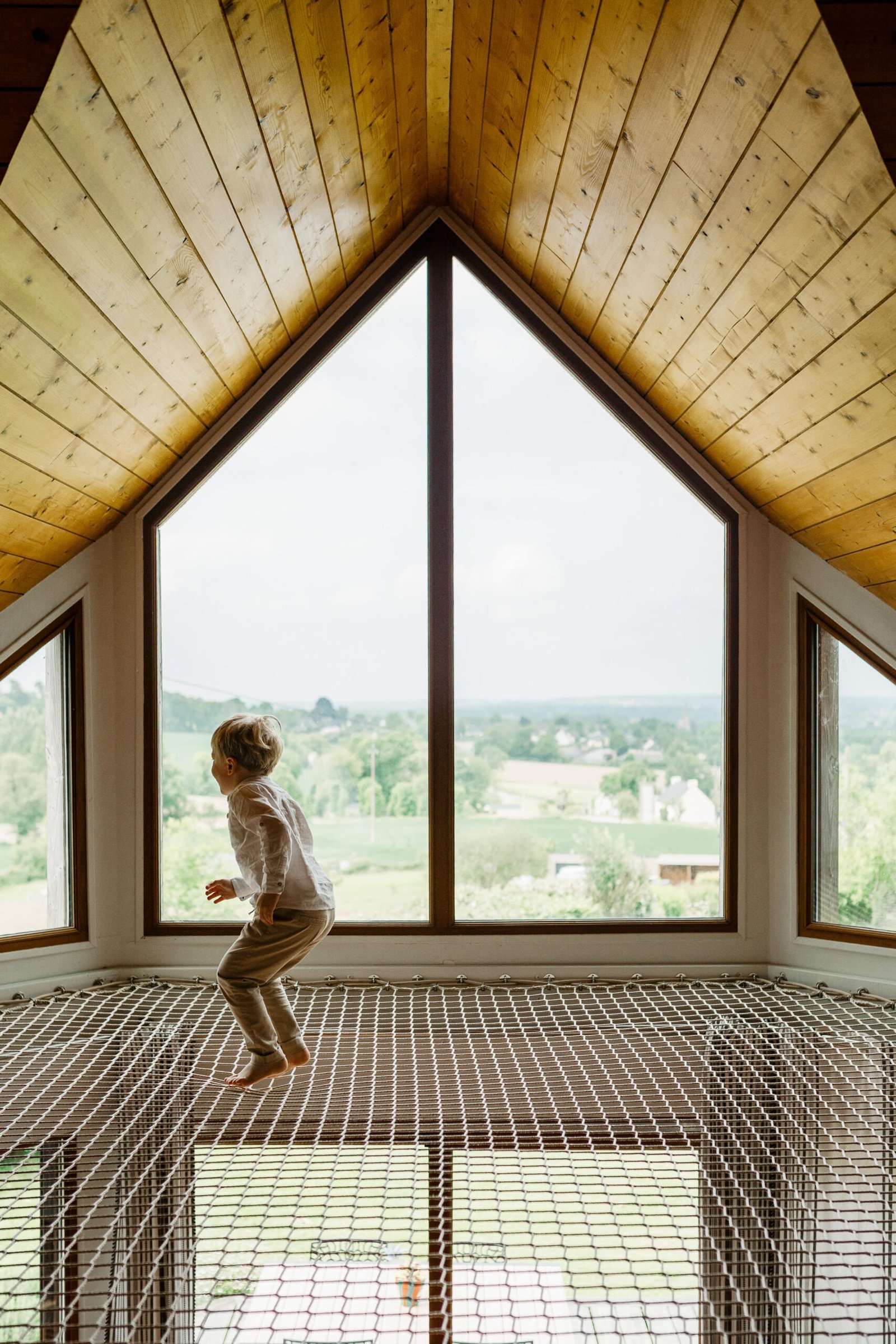 photo d'en enfant qui saute sur un filet dans une maison